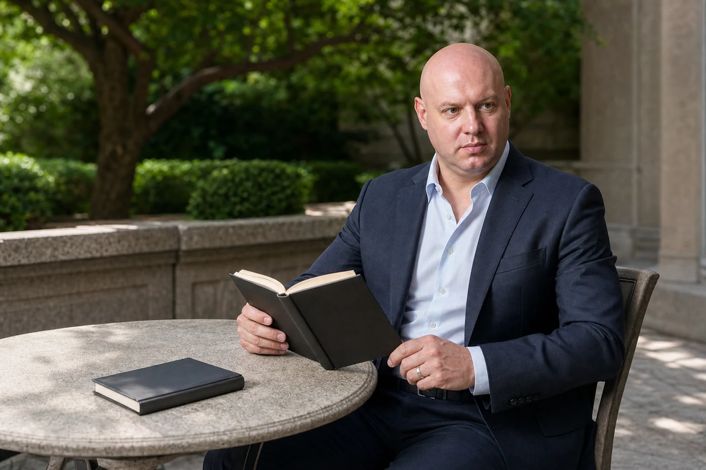 Joel Klemmer seated outdoors with an open book